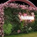 Stage With Headphone Shaped Arch Pink Flowers Green Plant Wall Neon Lights And Lawn Floor