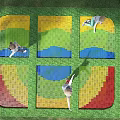Outdoor Children's Play Area With Colorful Geometric Mats And Kids Playing On Grass