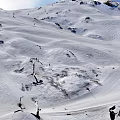 Skiing Scene On Snowy Mountain Slopes With Skiers And Clear Blue Sky