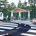 Modern Post Station With Canopy Structure Green Trees Pedestrians And Natural Surroundings