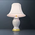 White Table Lamp With White Lampshade And Golden Base Trim On Dark Background