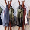 Stylish Clothes Hangers With Hanging Clothes Bags And Hats Against Geometric Patterned Wall