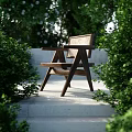 Wooden Rattan Outdoor Leisure Chair Surrounded by Green Plants in Garden