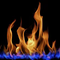 Warm Cozy Fireplace With Orange And Blue Burning Flames In Dark Background