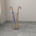 Golden Metal Mesh Umbrella Stand in Indoor Corner with Two Umbrellas and Wooden Handles