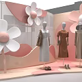 Fashion Window Display With Mannequins In Dresses And Large Pink Flower Decorations