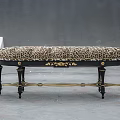 Elegant Leopard Print Upholstered Bench With Black Legs And Gold Accents On Gray Floor
