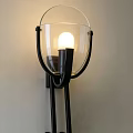 Modern Black Metal Wall Sconce with Transparent Glass Shade and Illuminated Bulb