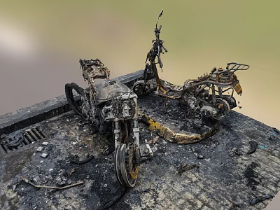 Burnt motorcycle with rusted parts and scattered ash and debris on outdoor ground 3d model