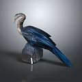 Flying Animal Bird Sculpture with Blue Brown Feathers Perched on Rock Against Gray Background