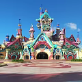Vibrant Theme Park Entrance Gate With Ornate Arched Design Colorful Spires And Plaza Greenery