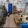 Indoor Gardening Space With Metal Shelves Plants Blue Barrel Wooden Table Flower Pots Red Cart