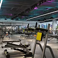 Modern Gym Interior Featuring Various Fitness Equipment Weight Machines Workout Benches and Bright Lighting