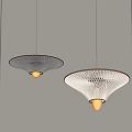 Two Modern Illuminated Pendant Lights With Perforated Shades Hanging In Light Gray Room