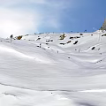 Skiing Scene On Snowy Mountain Slopes With Skiers And Clear Blue Sky