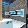 USHIO Exhibition Booth With Modern Design Multiple Blue Screens And People Interacting