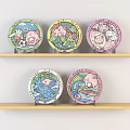 Five Colorful Cartoon Plates With Cute Patterns Displayed On Wooden Shelves