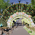 Peacock Feather Decorated Arched Entrance Gate With Grass Trees Stone Pathway And People Walking