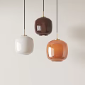 Three Colorful Ceramic Pendant Lights in White Brown Orange with Gold Accents on Light Background