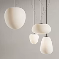 Modern White Pendant Lights With Various Shapes Hanging Against Gray Wall