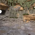 Cave Interior With Rock Formations Stalactites Hanging Plants And Stone Floor