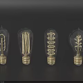 Vintage Glass Light Bulbs With Gold Base And Filament On Dark Background