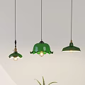 Green Pendant Lights With Floral Bell Shapes Above Green Table With Teapot And Plant