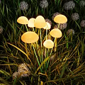 Mushroom Shaped Outdoor Lights Glowing Warmly Among Green Grass in Garden