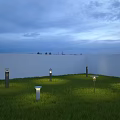 Outdoor Lights Illuminating Green Grass with White Wall and Evening Sky