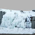 Garden Landscape With Thick Snow On Rocks And Cascading Ice Waterfall
