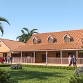 Single Family House With Orange Roof Palm Trees Green Lawn And Wooden Porch Area