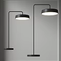 Two Modern Black Floor Lamps With Round Shades Illuminated In Minimalist Interior