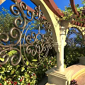 Ornate Ironwork Water Fountain In Arched Garden With Climbing Vines And Colorful Flowers