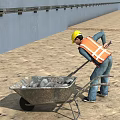 Construction site worker in yellow hard hat and orange safety vest pushing wheelbarrow with stones