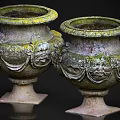 Garden Landscape Decorative Stone Urns With Carved Faces And Mossy Surface