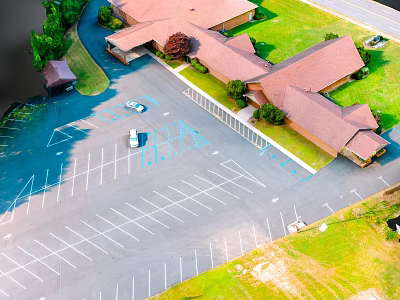 Aerial View Of Parking Lot With Buildings Grass Area And Trees 3d model