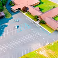 Aerial View Of Parking Lot With Buildings Grass Area And Trees