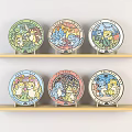 Colorful Round Plates With Cartoon Patterns On Two Wooden Shelves