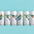 Six Beverage Cans With Colorful Bird And Fruit Designs On Light Blue Background
