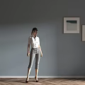 Woman Standing Against Gray Wall Two Paintings Herringbone Wooden Floor Wearing White Shirt Gray Pants