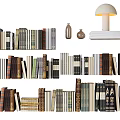 Various Colored Books Collection In Multiple Rows With Table Lamp And Small Bottles