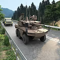 Military Wheeled Tank Driving On Road With Yellow Truck Surrounded By Trees And Mountains