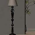 Elegant Black Floor Lamp With Decorative Column Design Against Beige Wall And Green Plant