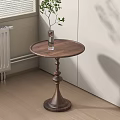 Round Wooden Side Table with Decorative Pedestal and Green Plant in Room Corner