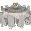 Elegant Round Dining Table Set With White Tablecloth Floral Centerpiece And White Chairs