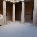 Ancient Stone Columns in Historical Building Interior with Rough Stone Walls and Earthen Floor