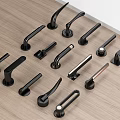 Black Door Handles In Various Styles Arranged On Wooden Tabletop