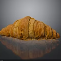 Freshly Baked Croissant With Golden Brown Flaky Layers On Black Surface With Reflection
