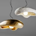 Modern Artistic Pendant Lights in Gold and White with Irregular Metallic Shapes Glowing Brightly