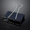 Silver Metal Paper Clip With Black Base And Reflective Surface For Office Use